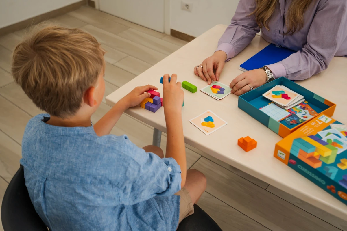 Bambino che gioca con cubi colorati durante una seduta di logopedia nello studio di Viterbo