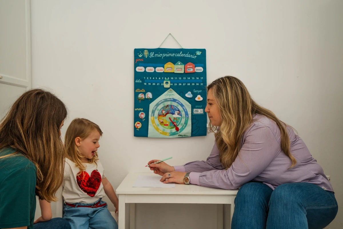 Mariangela conduce una attivita di logopedia con due bambine al tavolo nello studio di Viterbo